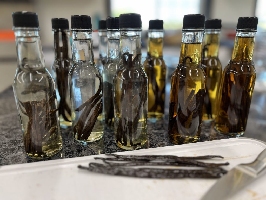 bottles of home made vanilla extract in front of a cutting board